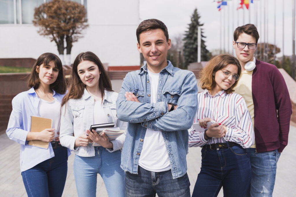 man surrounded by smart students with books looking camera